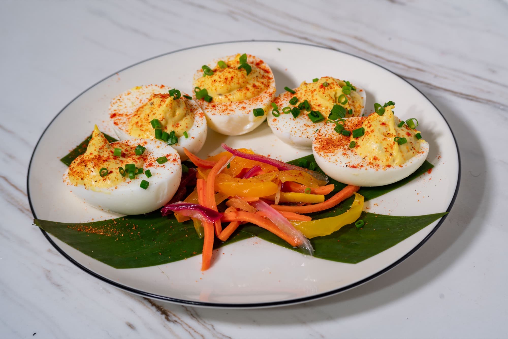 Poppy's Sunday Eggs plated on a banana leaf with pickled atchara