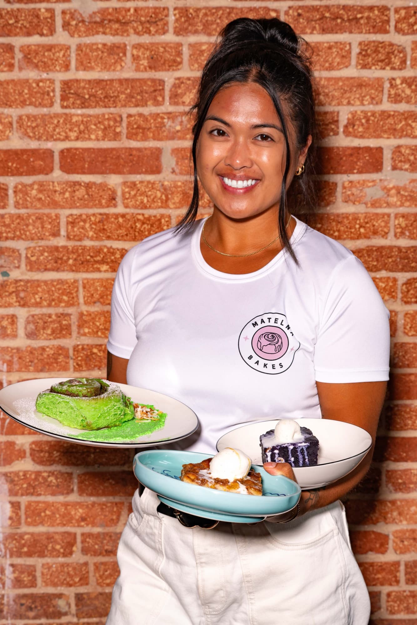Matelna balancing both desserts against the brick wall